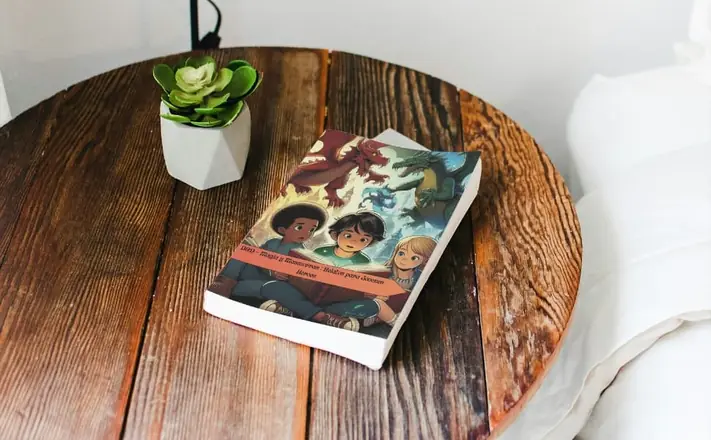 Libro Magia y Mazmorras: relatos para jóvenes héroes, sobre una mesita redonda de madera junto a una suculenta.